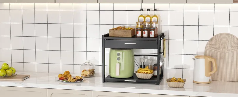 Black microwave stand holding an air fryer in a tiled kitchen